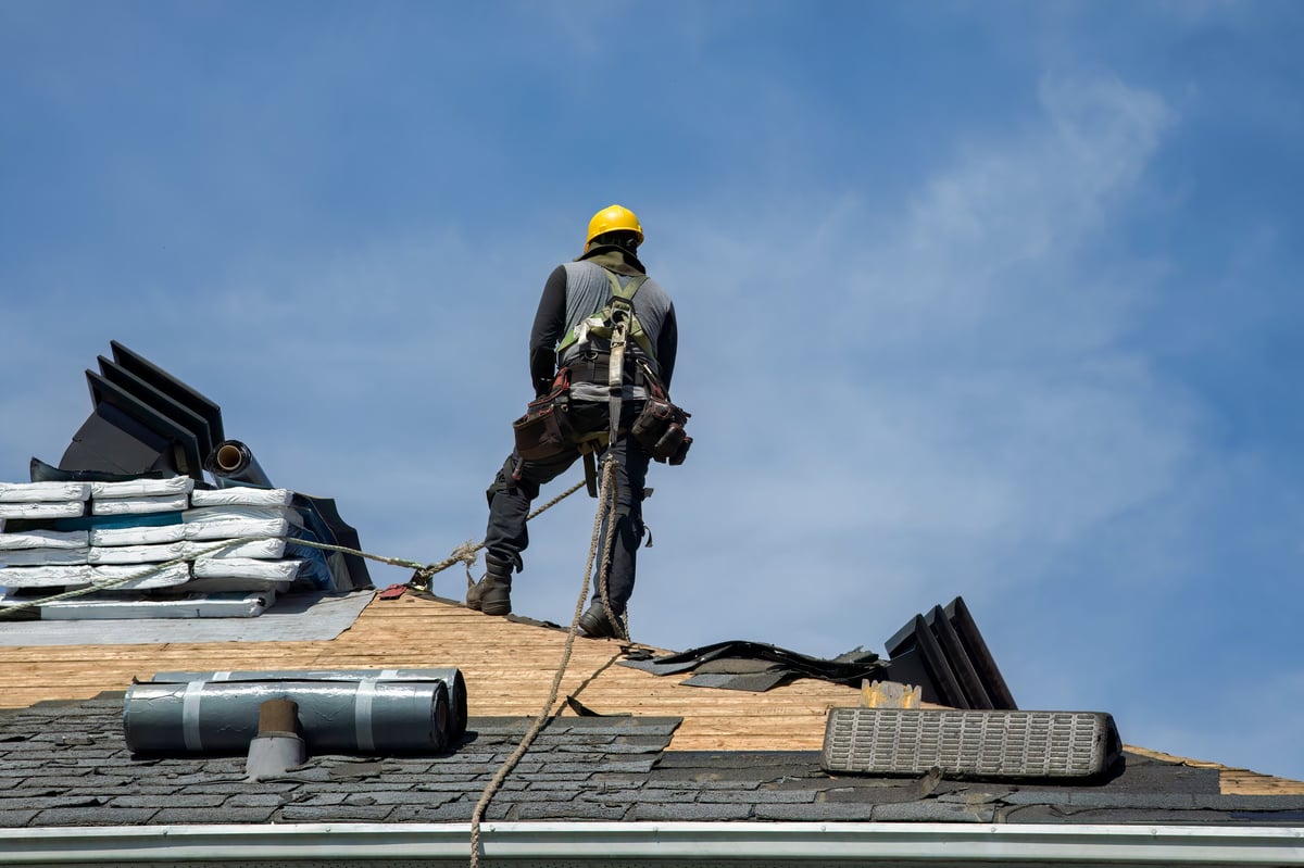 Roofing contractor securing a storm-damaged roof