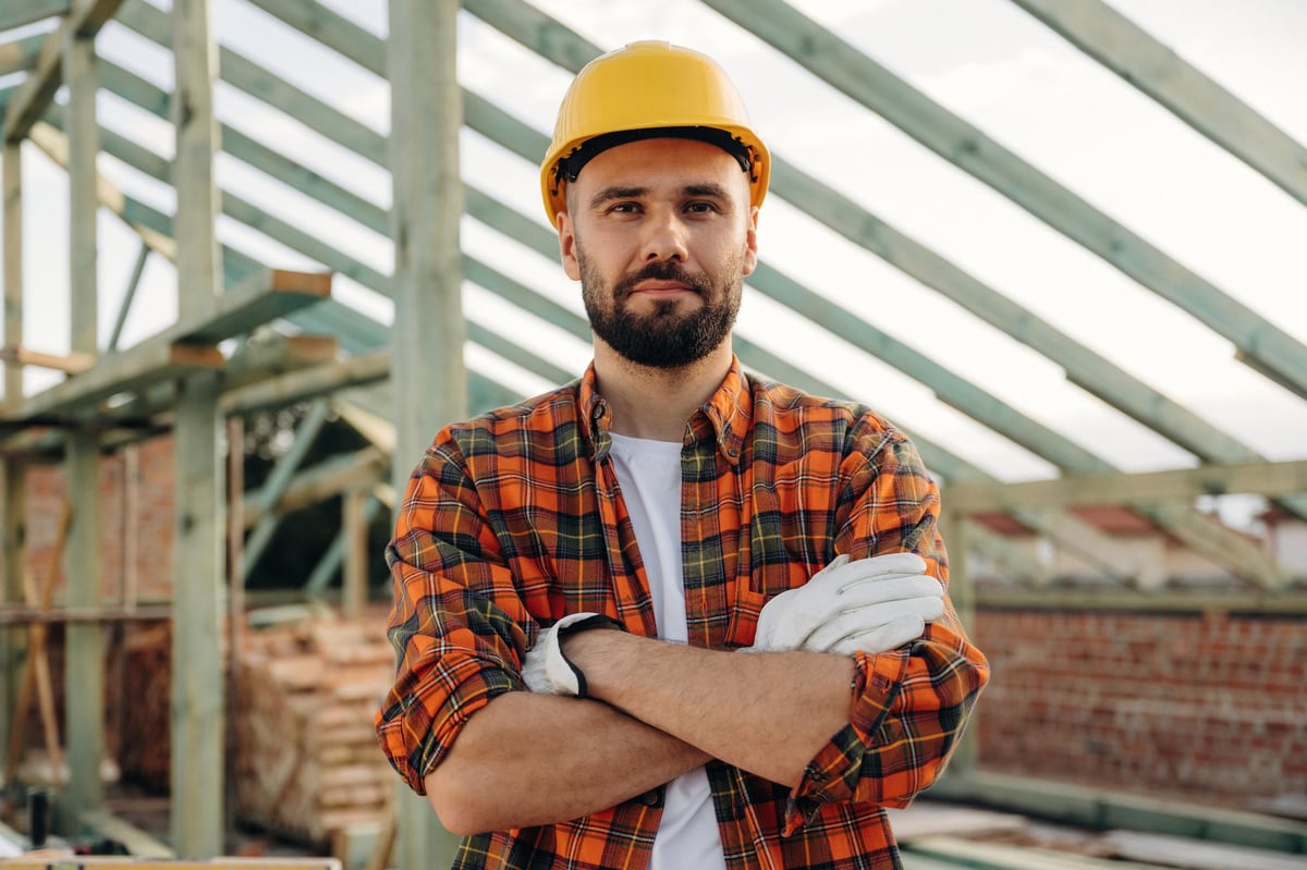 Roofing contractor inspecting a storm-damaged home roof